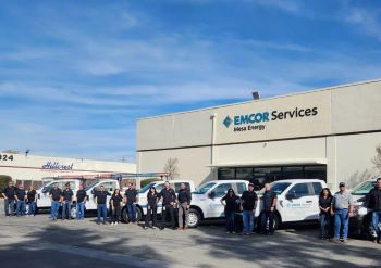 Employees standing by service trucks outside of the EMCOR Services Mesa Energy office